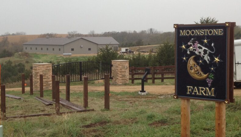 View of property on misty day, with large Moonstone Farm sign on right.