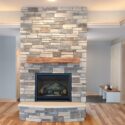 Floor-to-ceiling stone fireplace in residential side of building.