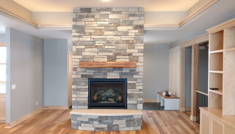 Floor-to-ceiling stone fireplace in residential side of building.