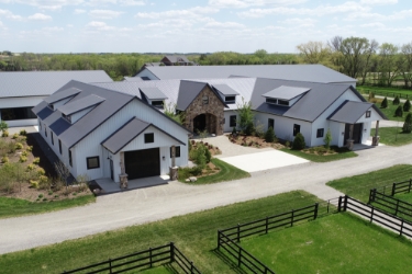 Front of equestrian facility. White buildings with light gray roof.