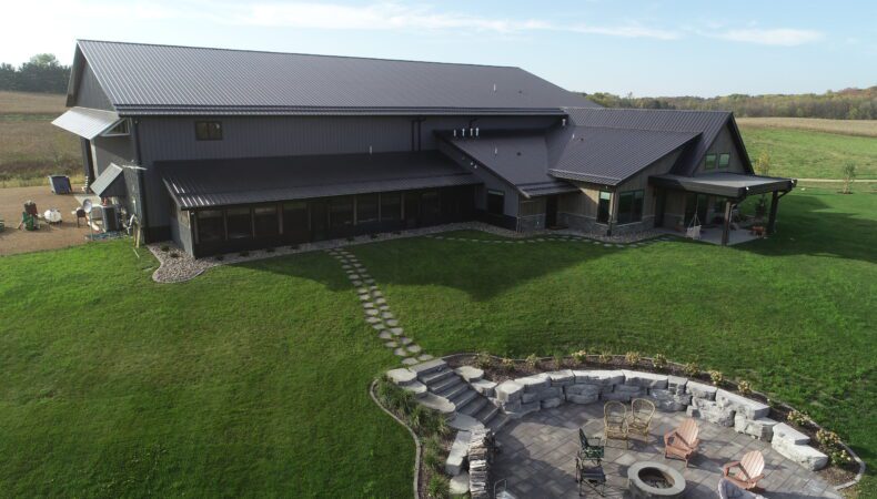 Front view of home and yard with landscaped firepit area.