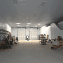 View of large garage space with 2 tall garage doors