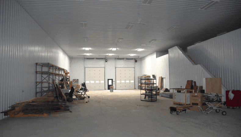 View of large garage space with 2 tall garage doors