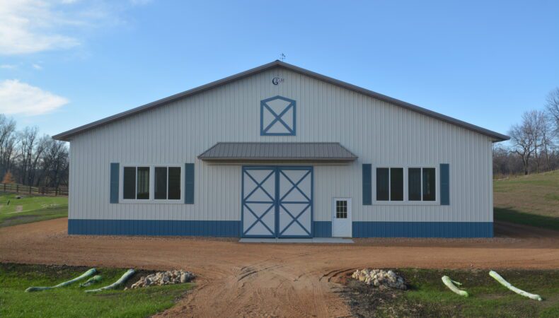 Front view of building with white siding and blue features.