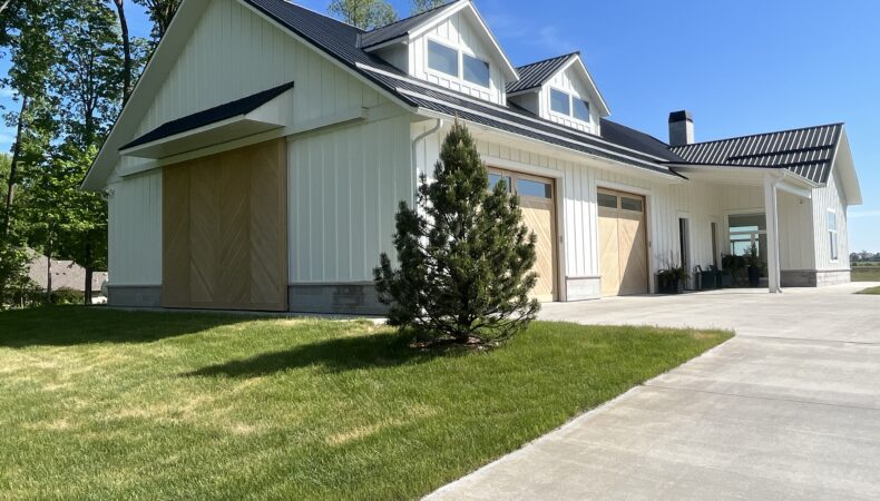 View of garage with wood barn doors covering large glass garage doors.