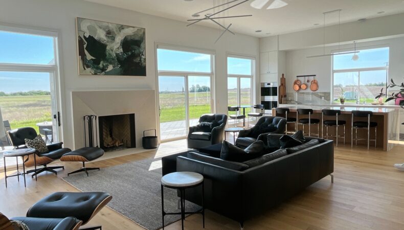 View of living room with fireplace feature and dining space in back.