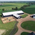 Aerial view of full property with one large equestrian facility and smaller building.