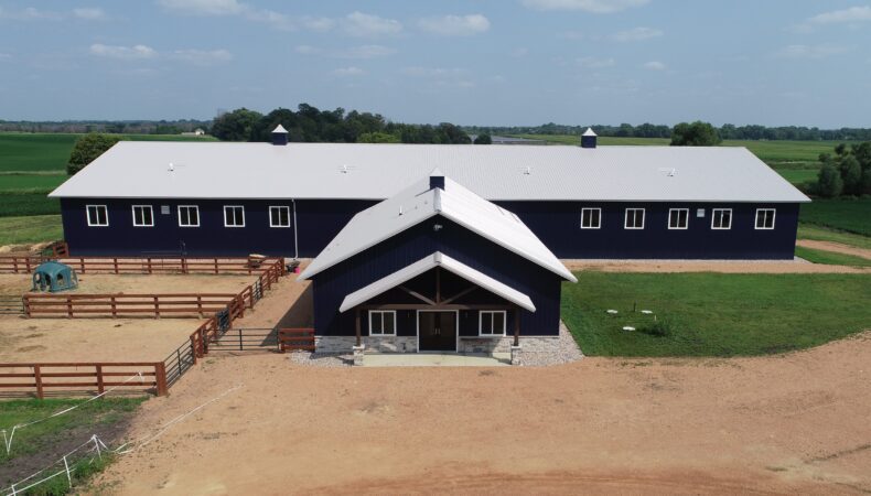 Front of equestrian building with fenced area to the left.