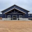 Entrance to equestrian building with blue siding and gray stone on bottom.