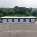 Large, long gray building with 6 garage doors