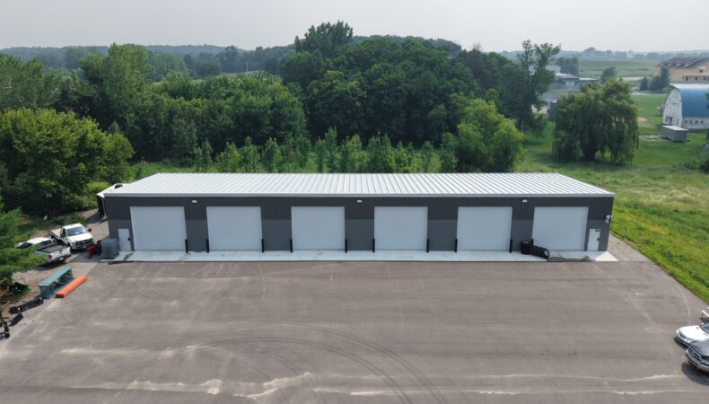 Large, long gray building with 6 garage doors
