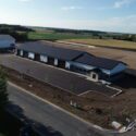Drone view of front of property including parking lot.
