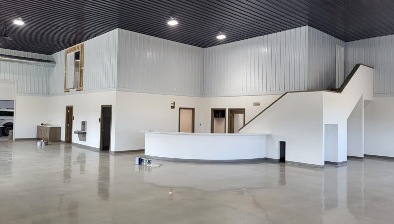 View of front desk and stairs from showroom floor.