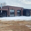 View of side of building with large glass garage doors.