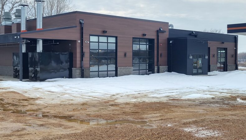 View of side of building with large glass garage doors.