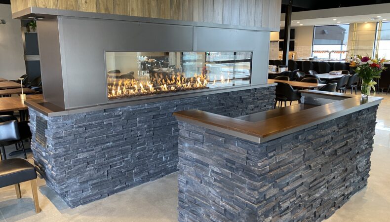 Entrance of restaurant with fireplace feature behind desk