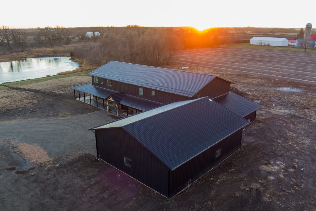 View of large post-frame home with dark siding and roofing.