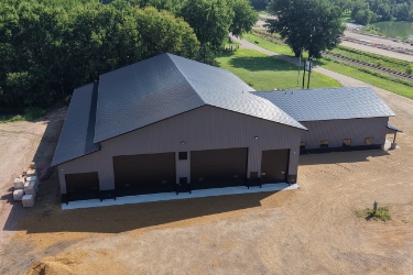 Exterior of commercial building that has dark gray siding, roofing, and doors.