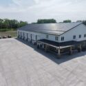 View of main building with covered entrance and large parking lot.