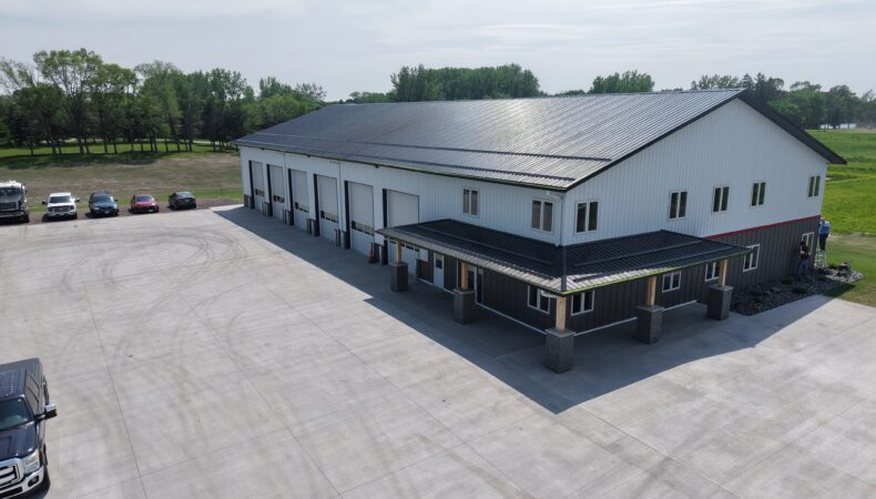 View of main building with covered entrance and large parking lot.