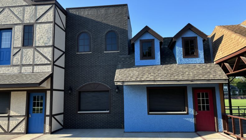 Left to right: Cream building, dark brick building, shorter blue building