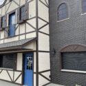 Side view of tan building with blue doors