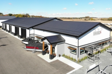 White commercial boat sales building with gray roof.