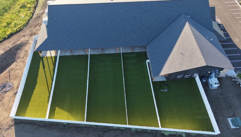 Drone view of fenced in play areas behind building