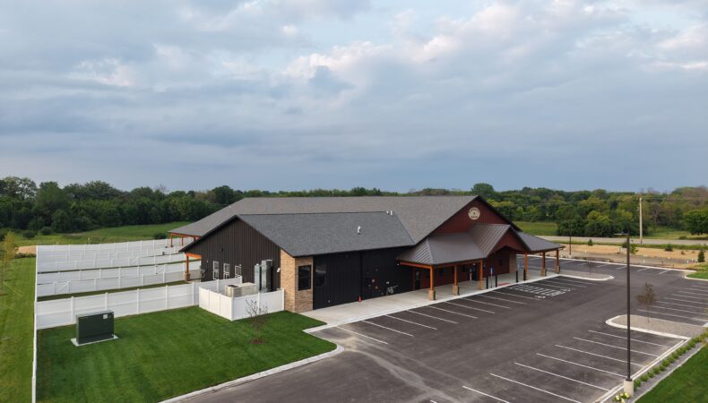 Front left side of building with fenced area on left.