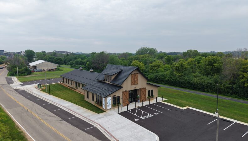 Zoomed out aerial view showing building and parking lot.